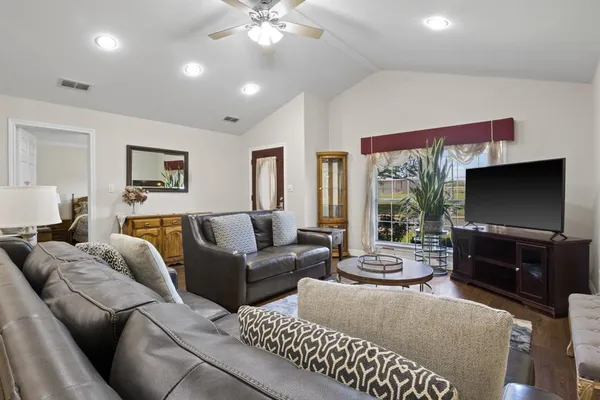 a living room with furniture a large window and a flat screen tv
