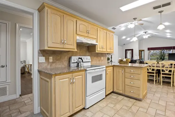 a kitchen with cabinets appliances and a window