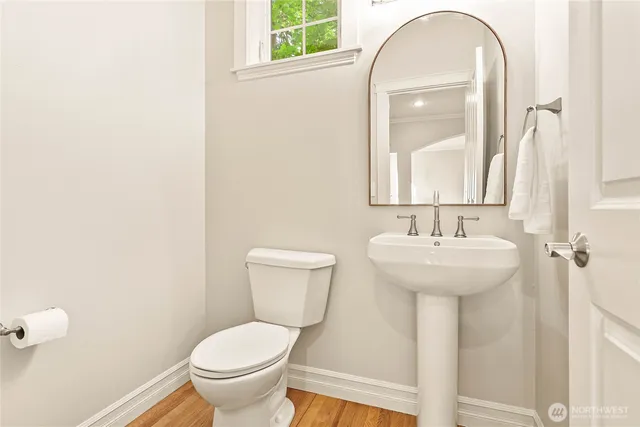 a bathroom with a toilet sink and mirror