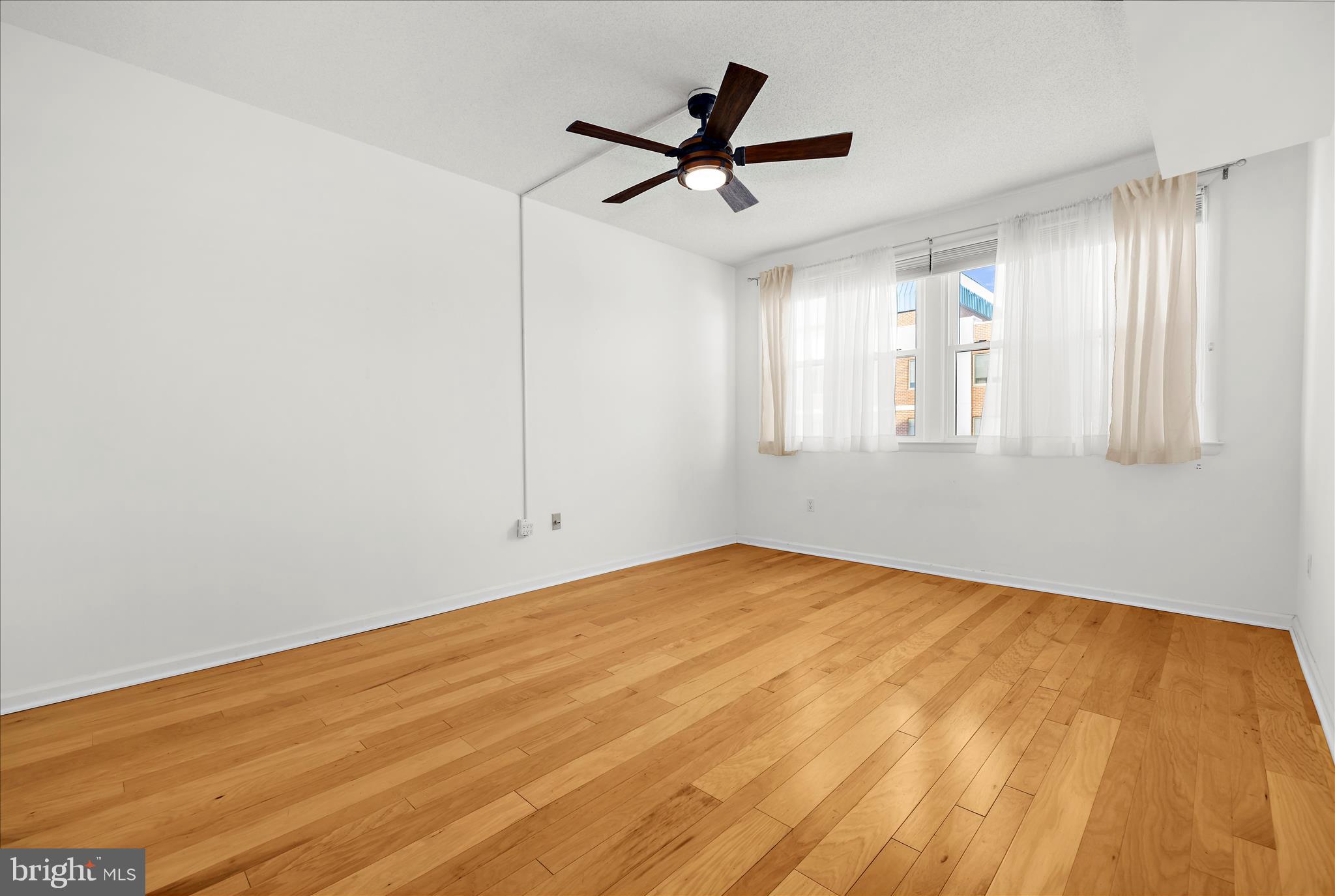 930 Astern Way, Unit 512 Annapolis, MD 21401 - Photo 23 of 58 a view of a big room with wooden floor a ceiling fan and windows