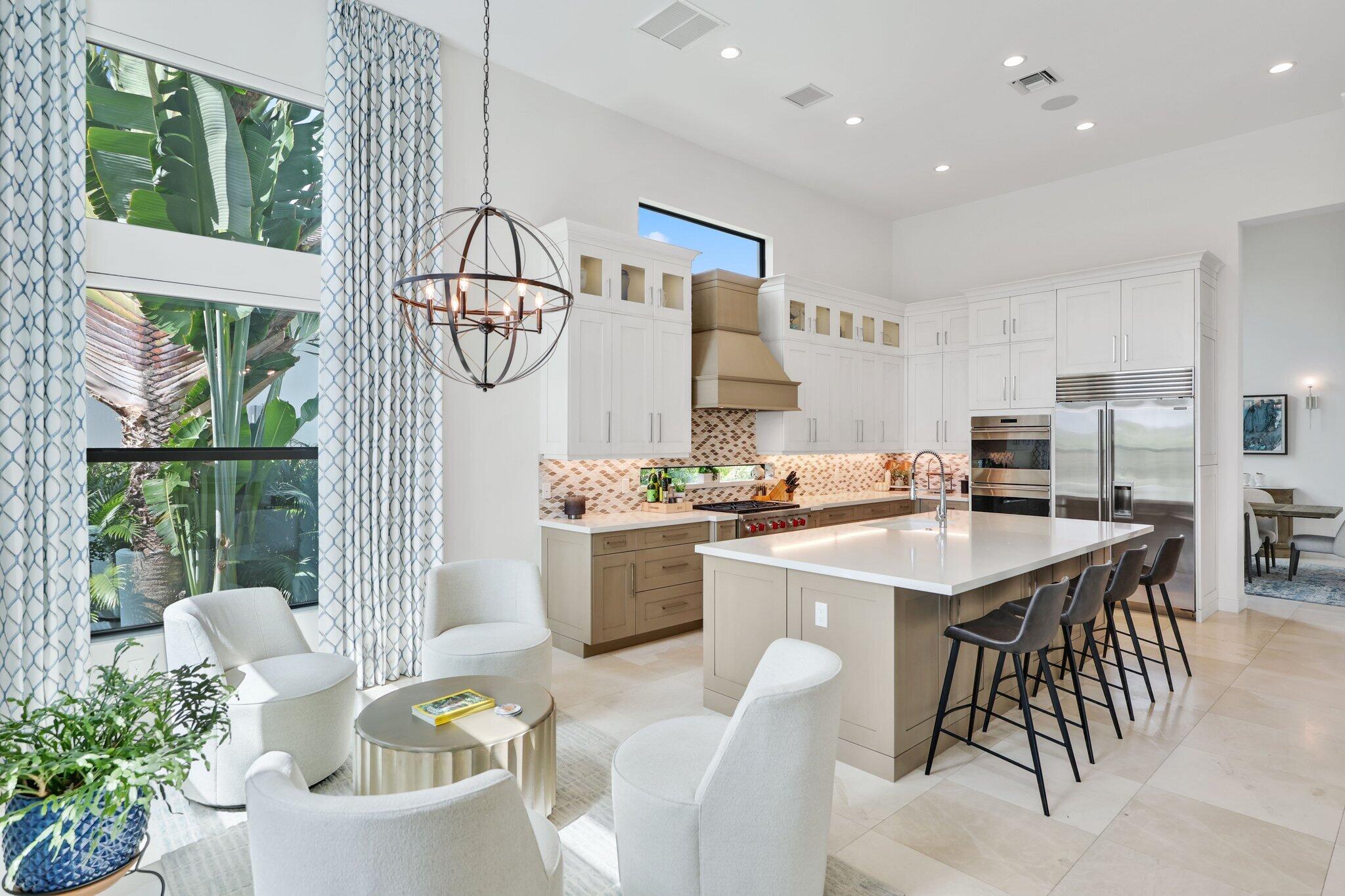 2530 Northwest 71st Street Boca Raton, FL 33496 - Photo 17 of 94 a kitchen with stainless steel appliances kitchen island granite countertop a stove a sink a dining table and chairs