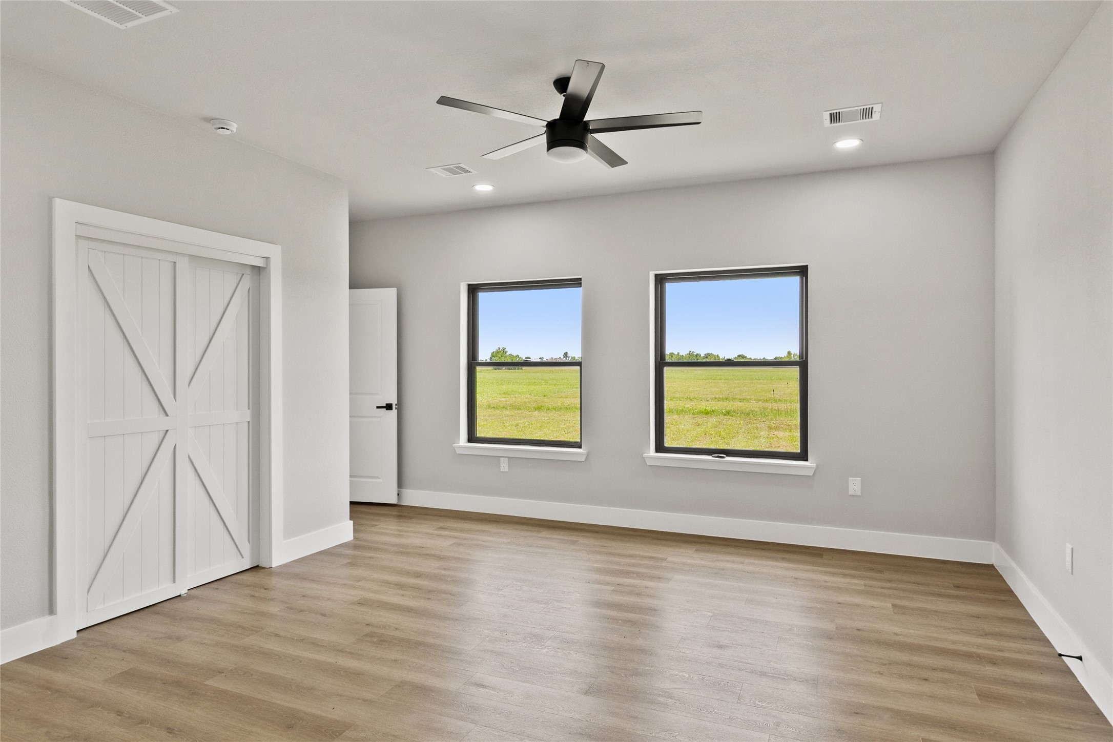 619 Chuckwagon Trail Angleton, TX 77515 - Photo 20 of 37 Relaxing primary suite with backyard views and a spa-inspired en suite bath featuring a fully tiled wet room, soaking tub, dual shower heads, double vanities, and a private water closet. The spacious walk-in closet includes built-in drawers for added organization.
