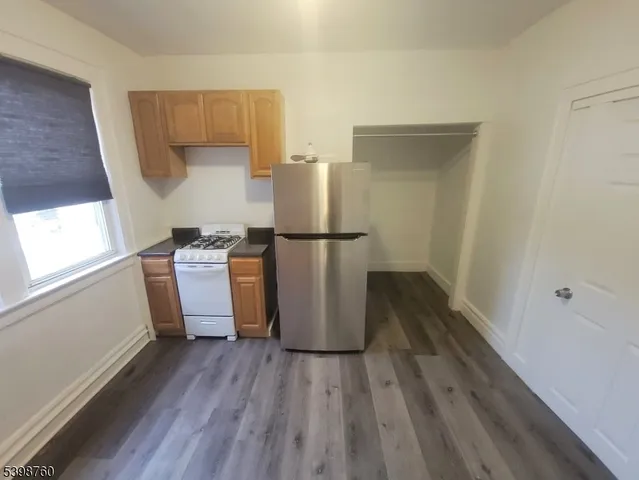 a view of a kitchen with wooden floor and electronic appliances