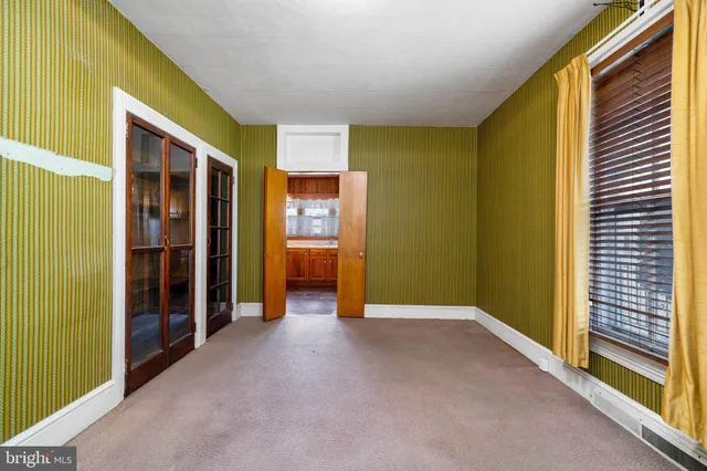 a view of an empty room with furniture and a window