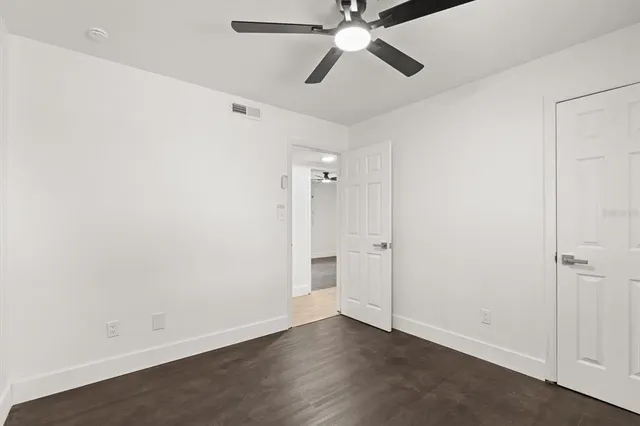 an empty room with closet and a chandelier fan
