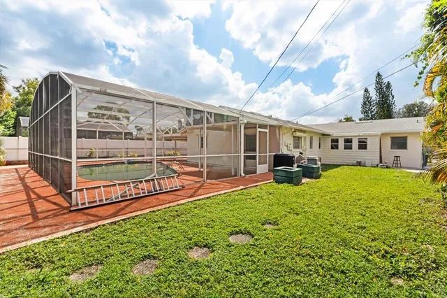 a view of a house with backyard and sitting area