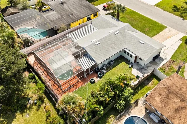 an aerial view of a house with a yard and outdoor seating