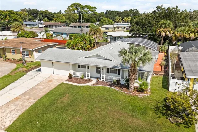 a view of a big house with a big yard and large trees