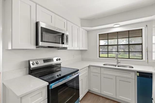 a kitchen with a sink stove and microwave