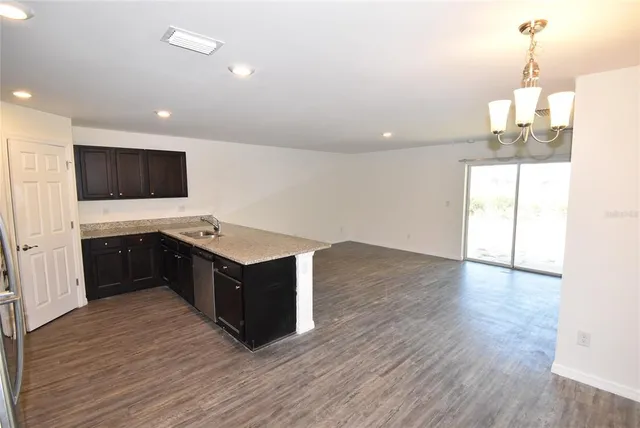 a kitchen with a stove and a wooden floor