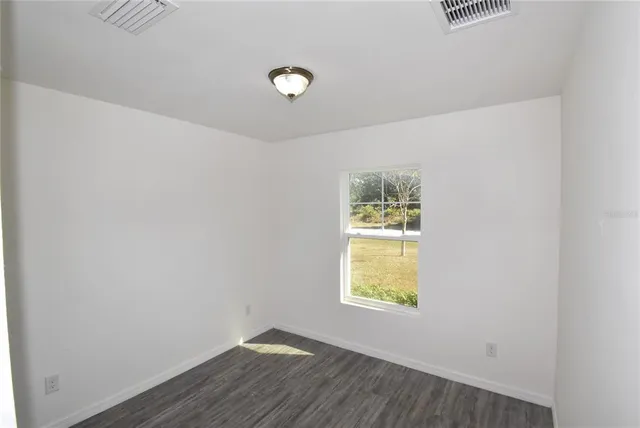 a view of room with window and wooden floor