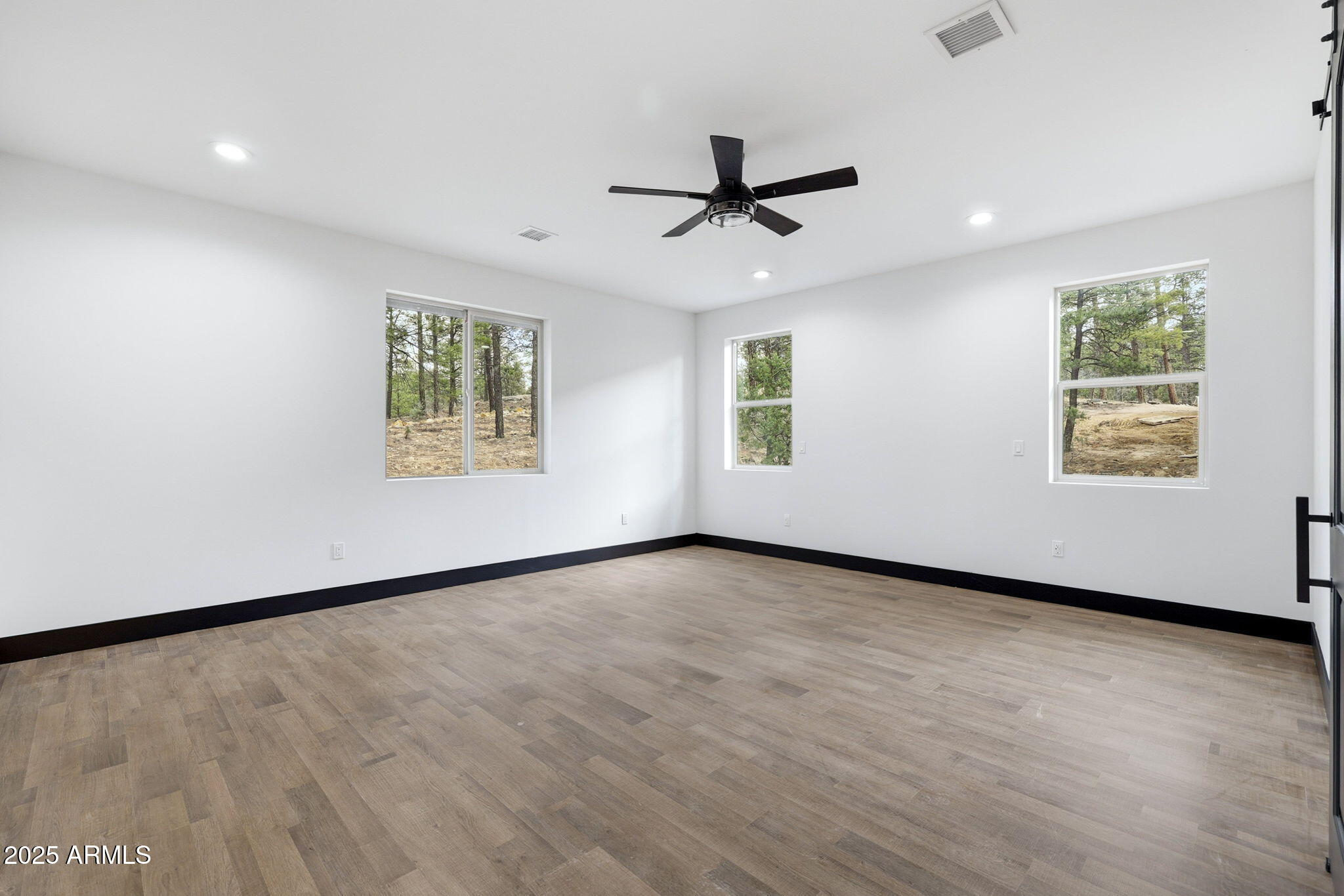 2400 West Bench Road Show Low, AZ 85901 - Photo 15 of 37 a view of an empty room with a window and wooden floor