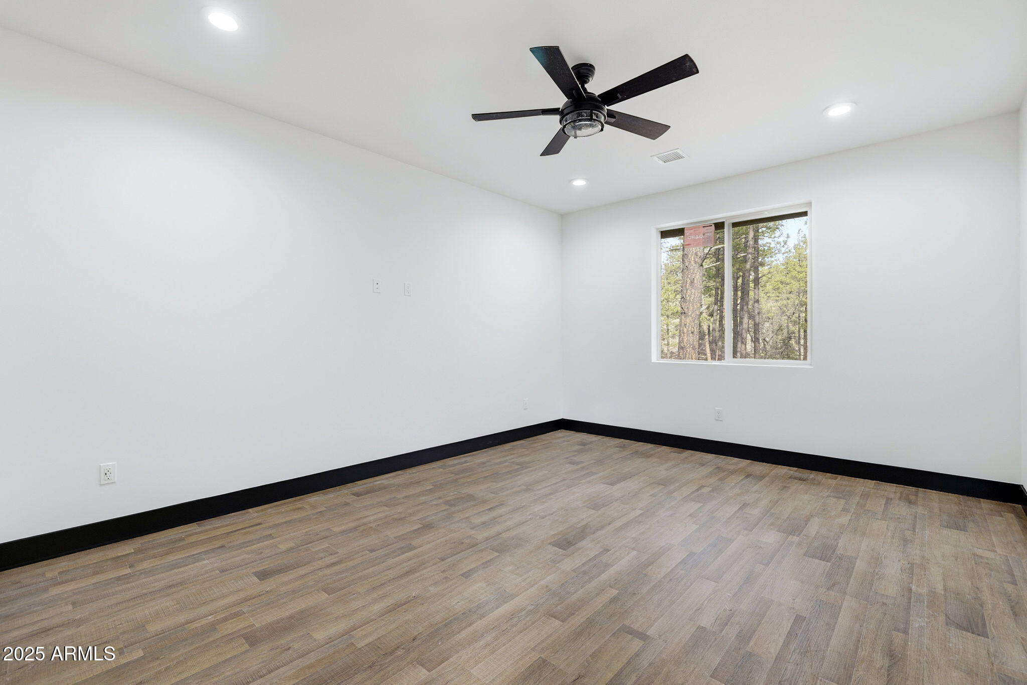 2400 West Bench Road Show Low, AZ 85901 - Photo 19 of 37 an empty room with wooden floor ceiling fan and windows