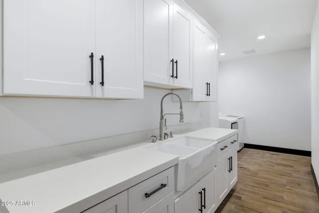 a kitchen with a sink cabinets and wooden floor