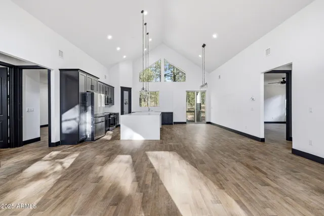 a view of a living room and kitchen with furniture wooden floor and window