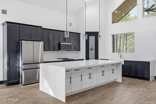 a kitchen with stainless steel appliances a refrigerator sink and cabinets