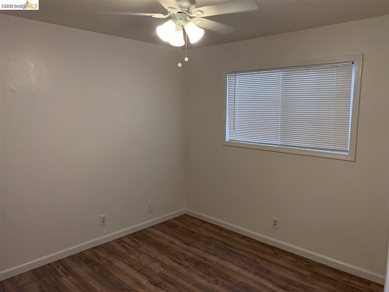 124 West 8th Street, Unit B Tracy, CA 95376 - Photo 5 of 11 an empty room with a window and wooden floor