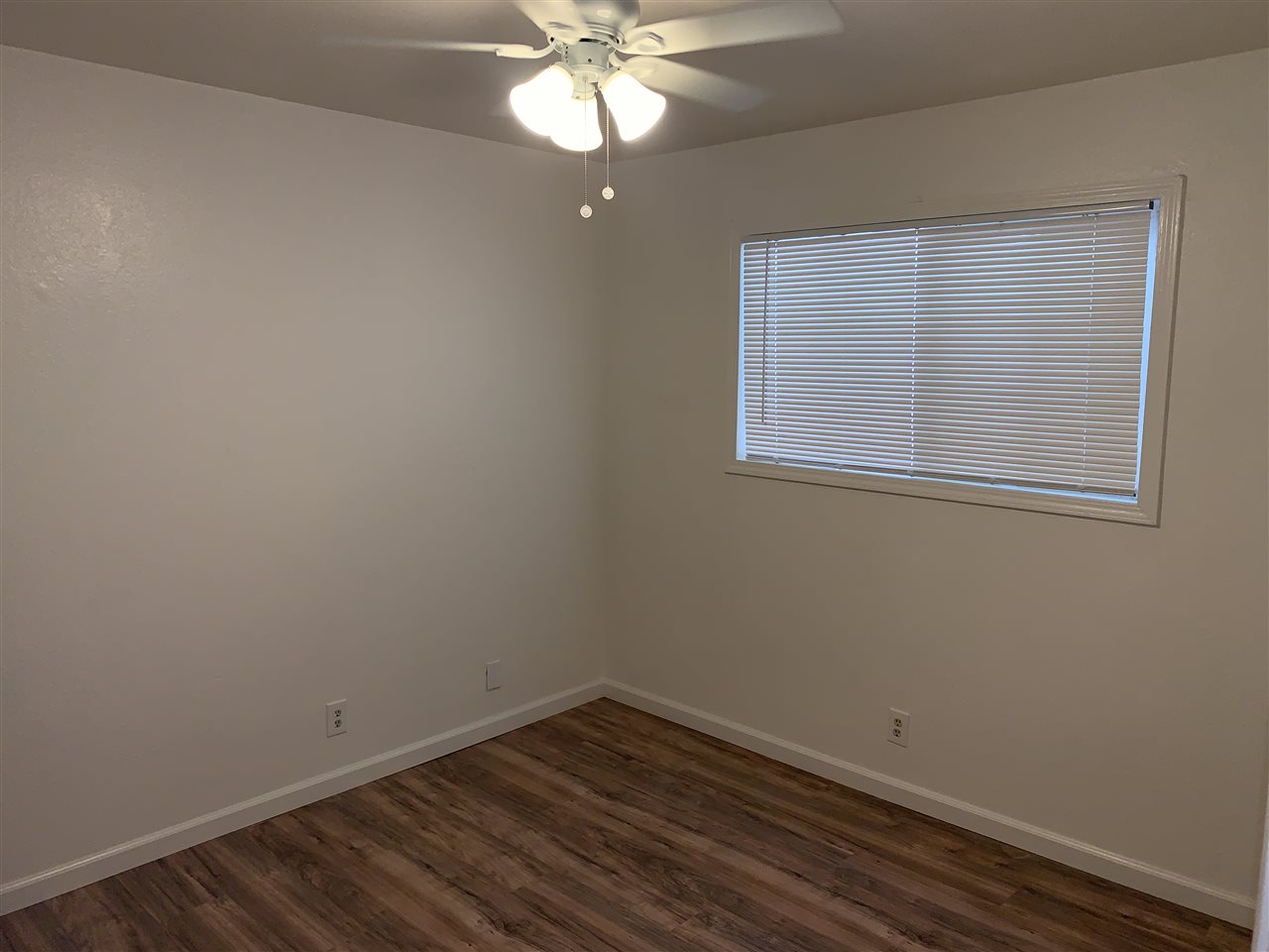 124 West 8th Street, Unit B Tracy, CA 95376 - Photo 5 of 11 an empty room with a window and wooden floor