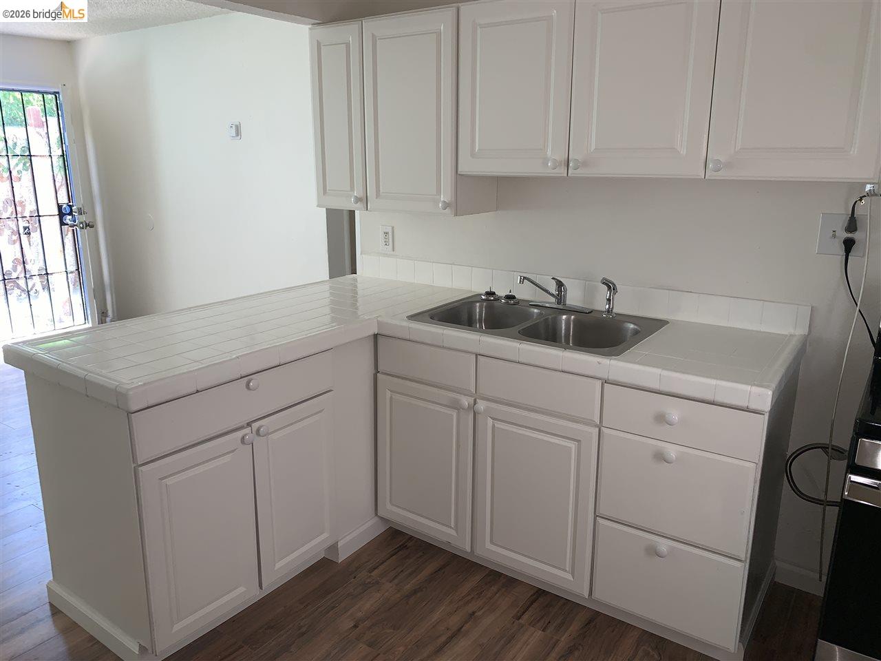 124 West 8th Street, Unit B Tracy, CA 95376 - Photo 10 of 11 a kitchen with white cabinets and white appliances