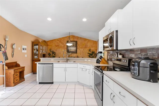 a kitchen with granite countertop a refrigerator and a stove top oven
