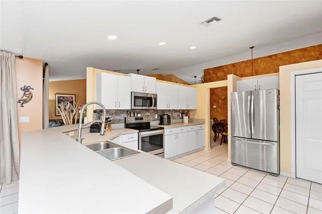 a kitchen with stainless steel appliances a refrigerator sink and stove