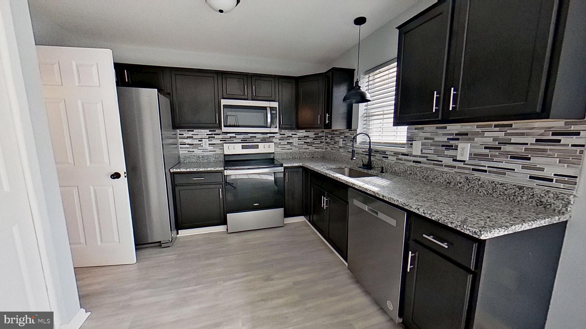 450 Fisher Drive York, PA 17404 - Photo 4 of 12 a kitchen with stainless steel appliances granite countertop a sink stove microwave and refrigerator