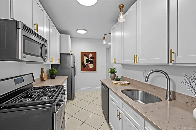 a kitchen with stainless steel appliances granite countertop a sink stove top oven and cabinets