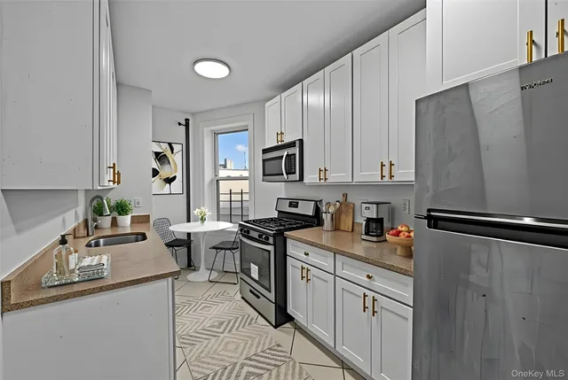 a kitchen with white cabinets and stainless steel appliances