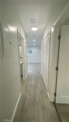 a view of an empty room with wooden floor and closet