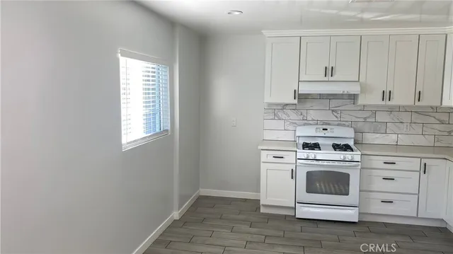 a white stove top oven sitting inside of a kitchen
