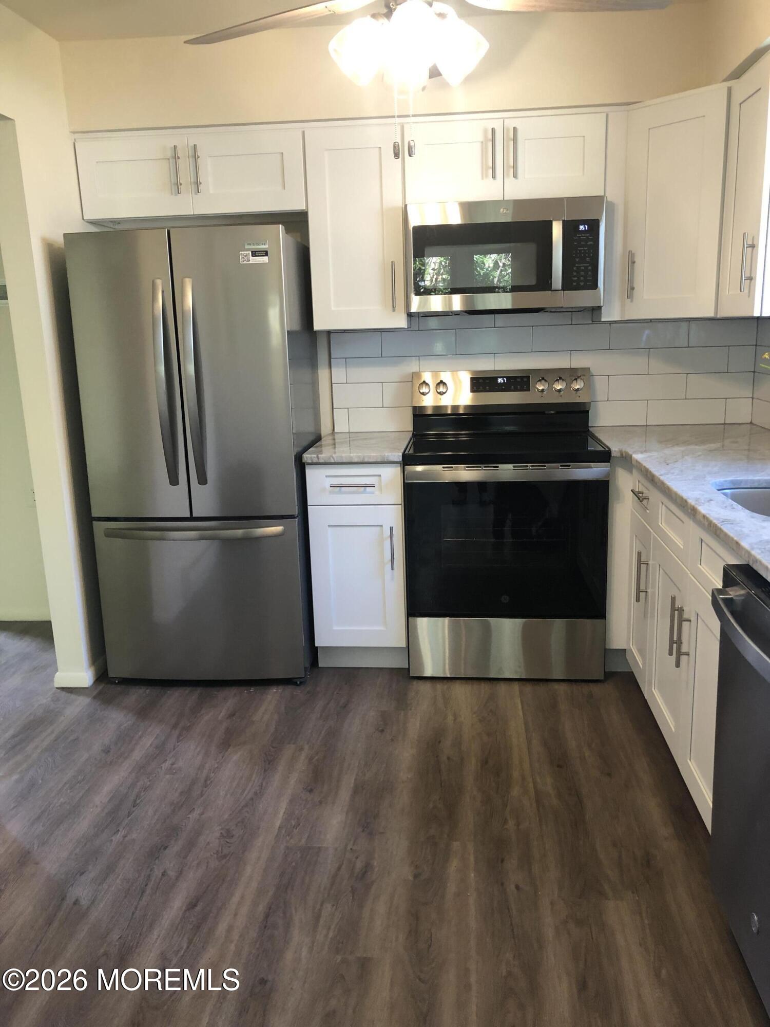 6 Dickinson Road Brick, NJ 08724 - Photo 4 of 17 a kitchen with stainless steel appliances and wooden cabinets