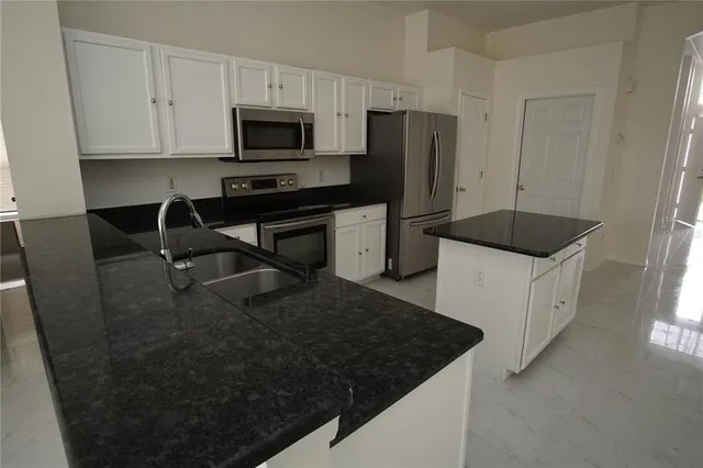 a kitchen with stainless steel appliances a stove a microwave a sink and a refrigerator