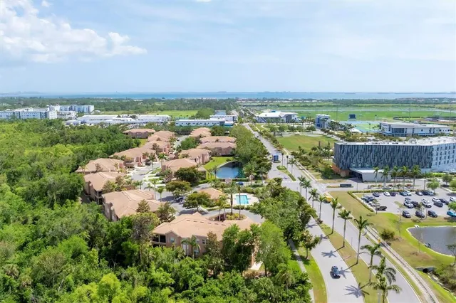 a sign board with a building and trees in the background