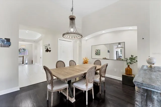 a view of a dining room and livingroom with furniture wooden floor a chandelier