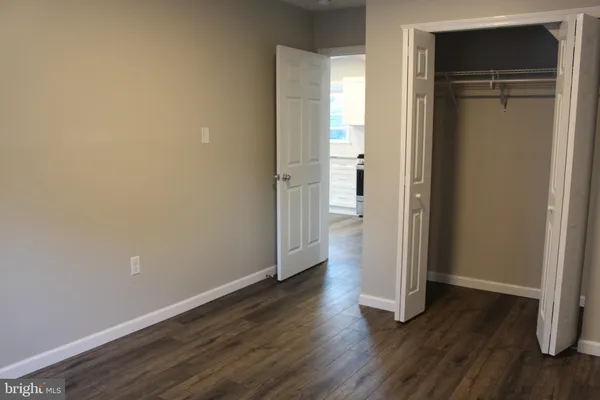 an empty room with wooden floor and closet