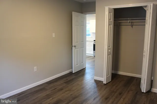 an empty room with wooden floor and closet