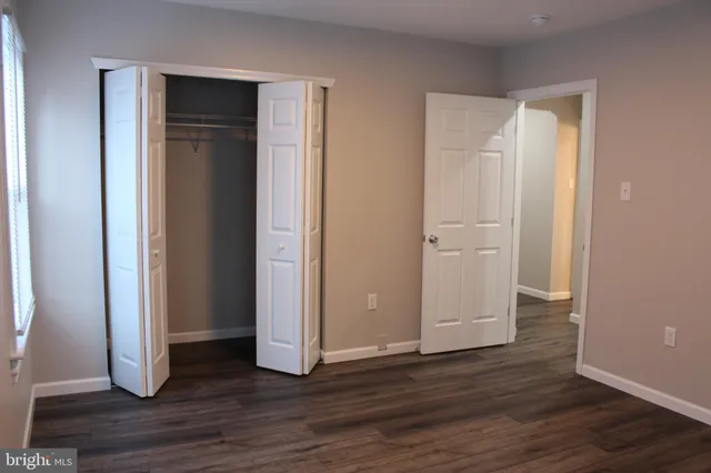 an empty room with wooden floor and closet