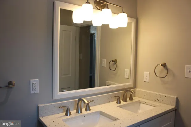 a bathroom with a granite countertop sink and a mirror