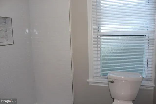 a bathroom with a toilet a sink and a window