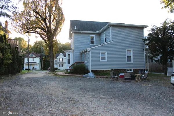 a view of a house with backyard and a tree
