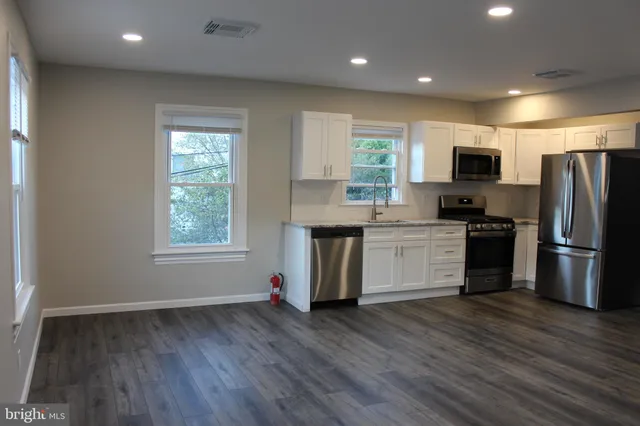 a kitchen with stainless steel appliances a refrigerator and a stove top oven