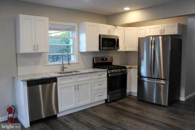 a kitchen with stainless steel appliances a refrigerator microwave and sink