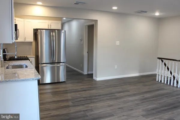 a kitchen with kitchen island stainless steel appliances a refrigerator and a sink