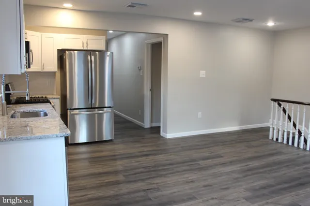 a kitchen with kitchen island stainless steel appliances a refrigerator and a sink