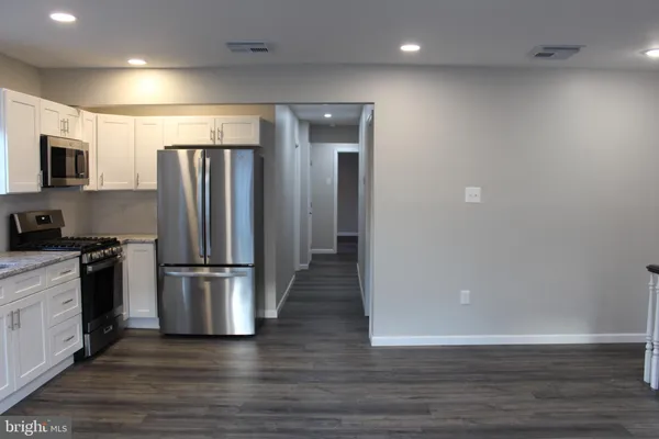 a kitchen with stainless steel appliances wooden floor and large window