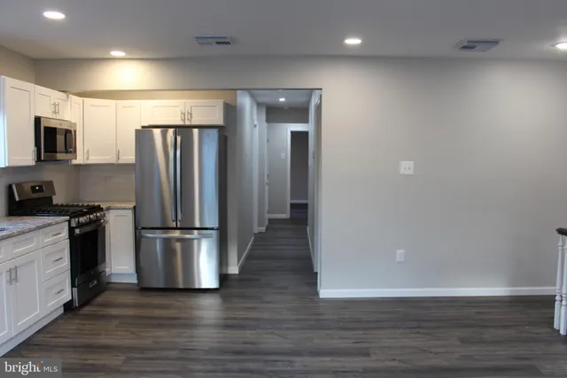 a kitchen with stainless steel appliances wooden floor and large window