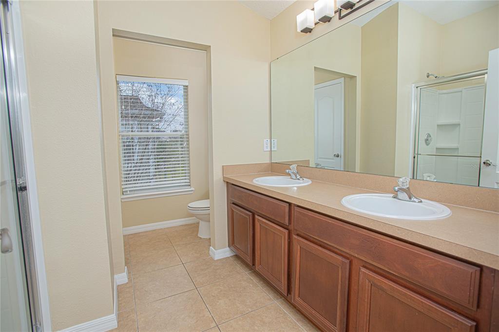 6468 South Goldenrod Road, Unit 34B Orlando, FL 32822 - Photo 19 of 34 a bathroom with a granite countertop sink a toilet and a mirror