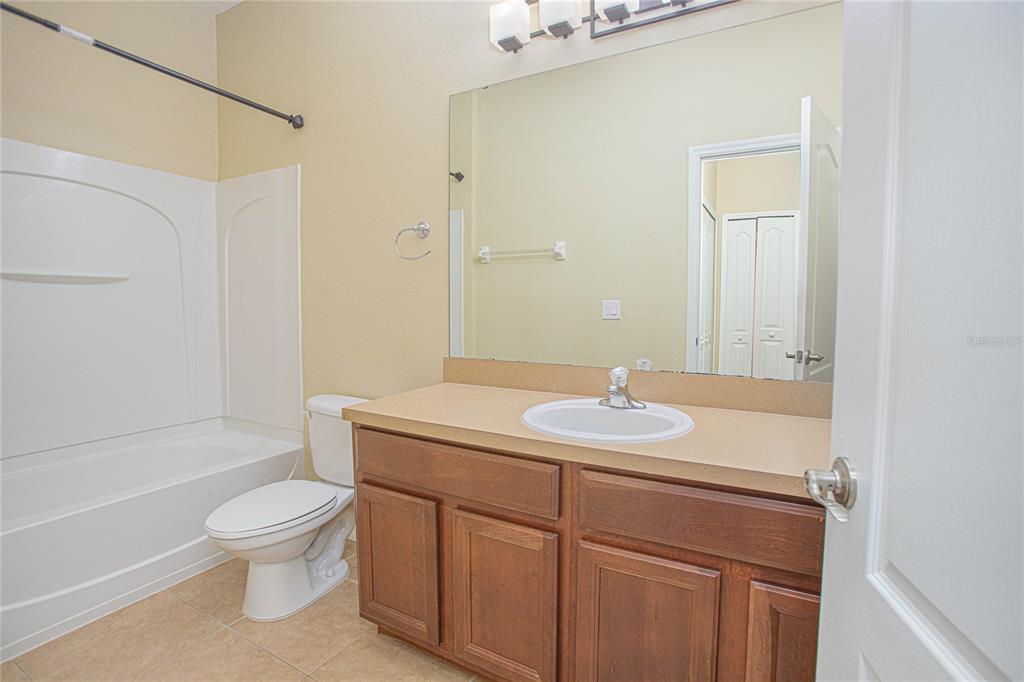 6468 South Goldenrod Road, Unit 34B Orlando, FL 32822 - Photo 21 of 34 a bathroom with a granite countertop sink toilet a mirror and shower