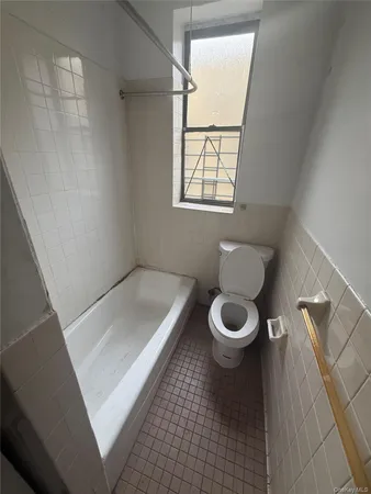 a white toilet sitting next to a window