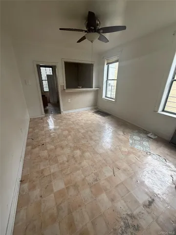 a view of an empty room with a fireplace and a window
